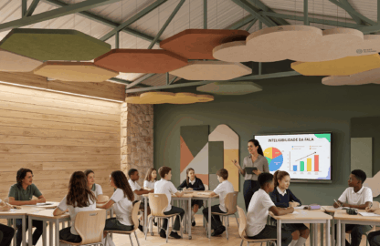 Professora e alunos em sala de aula contemporânea com teto decorado por nuvens acústicas suspensas e painéis de parede para redução de ruído.